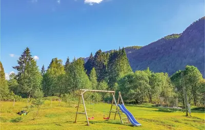 two swings in a field with mountains in the background at 3 Bedroom Lovely Home In Vikanes in Eiknes