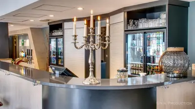 a bar in a restaurant with a vase on a counter at Fosen Fjord Hotel in Å i Åfjord