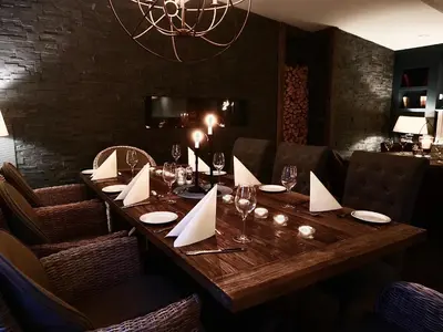 a long wooden table in a restaurant with wine glasses at Fosen Fjord Hotel in Å i Åfjord