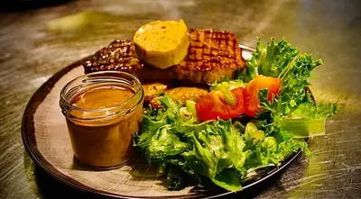 a plate of food with a salad and a jar of mustard at Fosen Fjord Hotel in Å i Åfjord