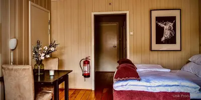 a room with a bed and a table and a fire extinguisher at Fosen Fjord Hotel in Å i Åfjord