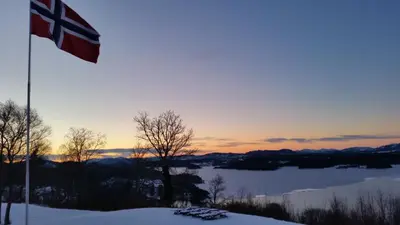 a flag in the snow with a view of a lake at Westland Hotel in Lindås