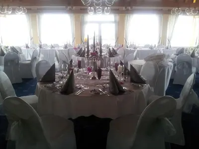 a dining room with white tables and white chairs at Westland Hotel in Lindås