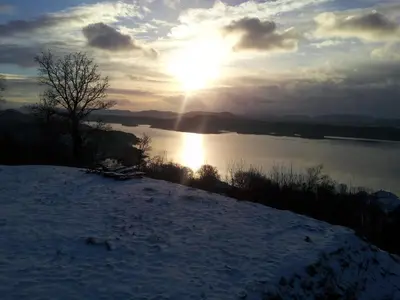 a sunset over a body of water with the sun setting at Westland Hotel in Lindås