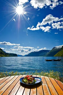 a plate of food on a table next to a lake at Havila Hotel Raftevold in Hornindal