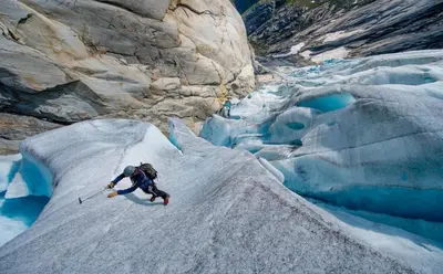 a man is jumping on an iceberg on a glacier at Havila Hotel Raftevold in Hornindal