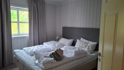 a bed with white sheets and pillows in a bedroom at Ålfotevegen 5 in Ålfoten