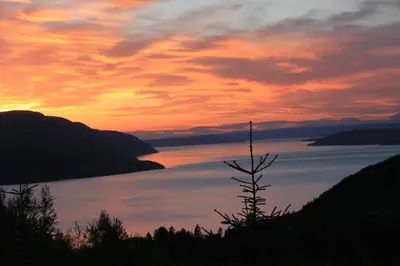 a sunset over a large body of water at Luxury Mountain Villa in Strandlykkja