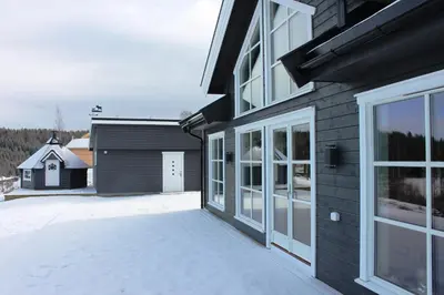 a house with a large window and a garage at Luxury Mountain Villa in Strandlykkja