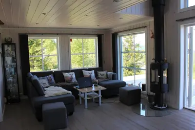 a living room with a couch and a tv at Luxury Mountain Villa in Strandlykkja