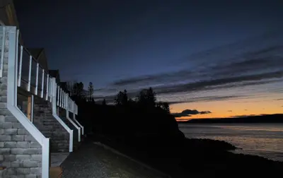 a building with a fence next to a body of water at Hjellup Fjordbo in Leksvik