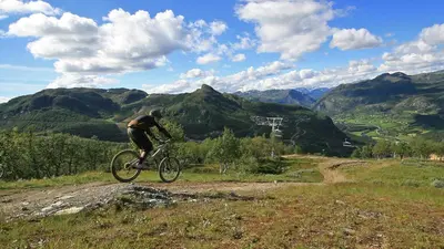 a man riding a bike on a mountain trail at Storehorn Apartments in Hemsedal