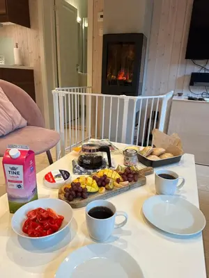 a table with a tray of food and cups of coffee at Fresh Familie Hytte Hemsedal with Outdoor Sauna in Hemsedal