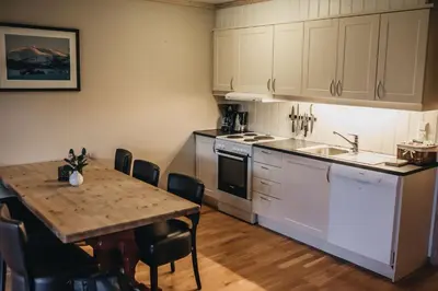 a kitchen with a table and a dining room at Hovdehytta in Hovden