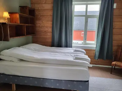 a bedroom with two beds in front of a window at Solheim Gard in Stryn