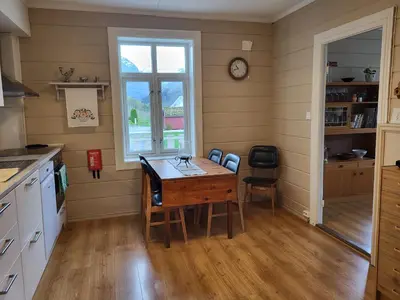 a kitchen with a wooden table and a window at Solheim Gard in Stryn