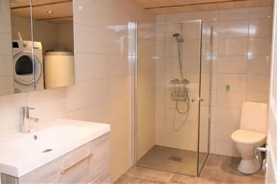 a bathroom with a shower with a sink and a toilet at Solheim Gard in Stryn