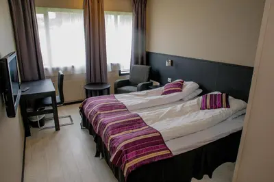 a hotel room with a bed and a desk and window at Systra Hotel Apartments Sjøholt in Sjøholt