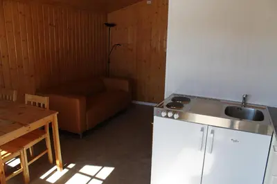 a kitchen with a sink and a couch in a room at Fjellstova Ørskogfjellet Cottages in Sjøholt