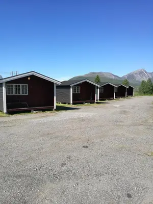 a row of buildings with mountains in the background at Fjellstova Ørskogfjellet Cottages in Sjøholt