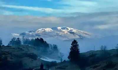 a snow covered mountain in the middle of a field at Skjerping gård in Lonevåg