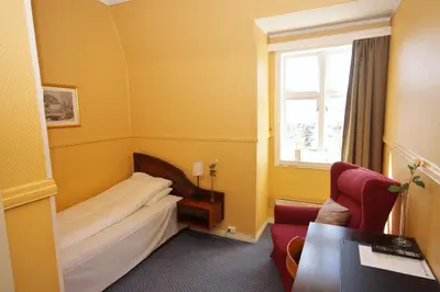 a hotel room with a bed and a window at Sauda Fjordhotell in Saudasjøen