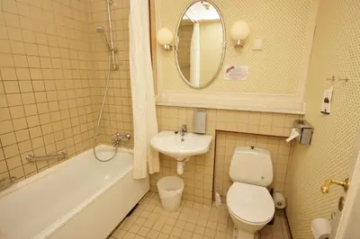 a bathroom with a sink and a toilet and a bath tub at Sauda Fjordhotell in Saudasjøen