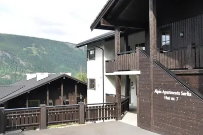 a building with a wooden fence in front of it at Alpin Apartments Sørlia in Hafjell