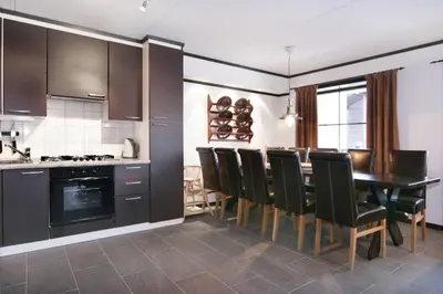 a kitchen with a dining room table and chairs at Alpin Apartments Sørlia in Hafjell