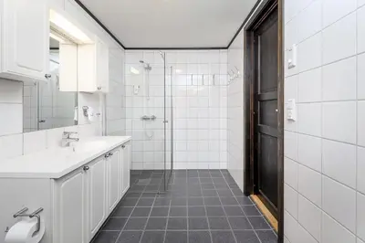 a white bathroom with a shower and a sink at Alpin Apartments Solsiden in Hafjell