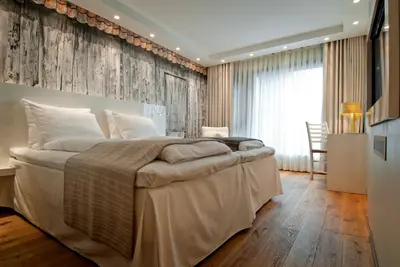 a bedroom with a large bed with a wooden floor at Panorama Hotell & Resort in Steinsland