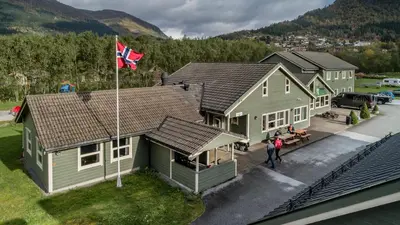 an aerial view of a house with a flag at Førde Gjestehus og Camping in Førde