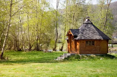 a small wooden cabin in a field of grass at Førde Gjestehus og Camping in Førde