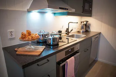 a kitchen with a sink and a counter with food in a bowl at Førde Gjestehus og Camping in Førde