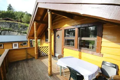 a balcony of a house with a table and chairs at Bratland Camping in Bergen
