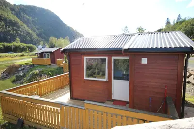 a small cabin on a deck with a fence at Bratland Camping in Bergen