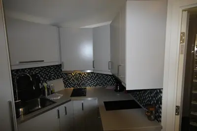 a small kitchen with white cabinets and a sink at Bratland Camping in Bergen