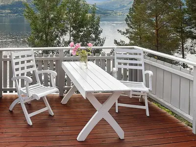 a white picnic table and two chairs on a deck at 8 person holiday home in EIDSVÅG-By Traum in Mittet