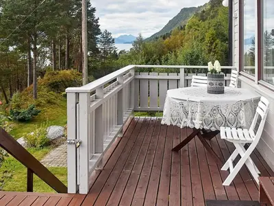 a table and chairs on a wooden deck with a view at 8 person holiday home in EIDSVÅG-By Traum in Mittet