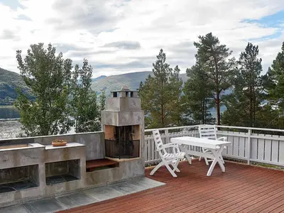 a outdoor grill with a table and chairs on a deck at 8 person holiday home in EIDSVÅG-By Traum in Mittet