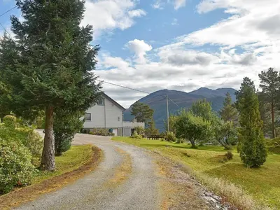 a dirt road next to a house with a tree at 8 person holiday home in EIDSVÅG-By Traum in Mittet