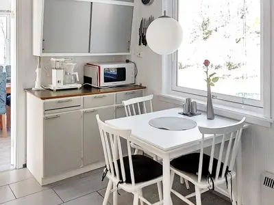 a kitchen with a table and chairs and a microwave at 8 person holiday home in EIDSVÅG-By Traum in Mittet