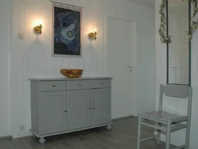 a white room with a chair and a dresser at 8 person holiday home in EIDSVÅG-By Traum in Mittet
