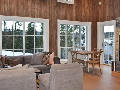 a living room with a couch and a table and windows at 5 person holiday home in Fåvang-By Traum in Favang