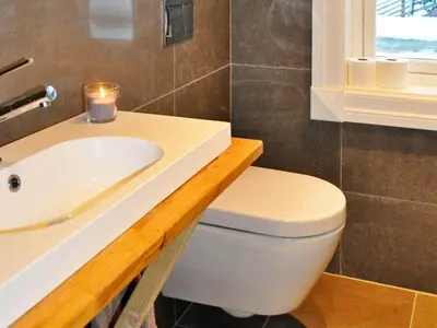 a bathroom with a toilet and a sink and a candle at 5 person holiday home in Fåvang-By Traum in Favang