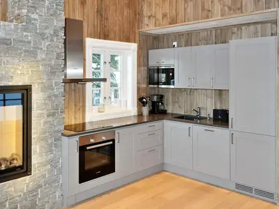 a kitchen with white cabinets and a stone wall at 5 person holiday home in Fåvang-By Traum in Favang