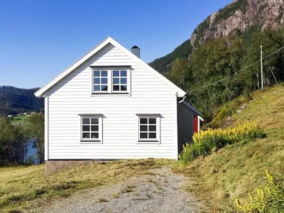 a white house on the side of a hill at 8 person holiday home in Masfjordnes-By Traum in Masfjorden