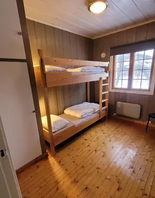 two bunk beds in a room with a wooden floor at Øen Turistsenter Cottages in Geilo