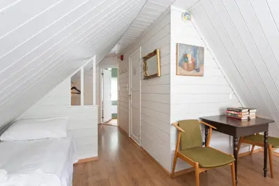a bedroom with a bed and a desk and a table at Jaunsen Gjestgjevarstad in Granvin