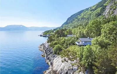 a house on a cliff next to the water at 3 Bedroom Cozy Home In Lavik in Lavik